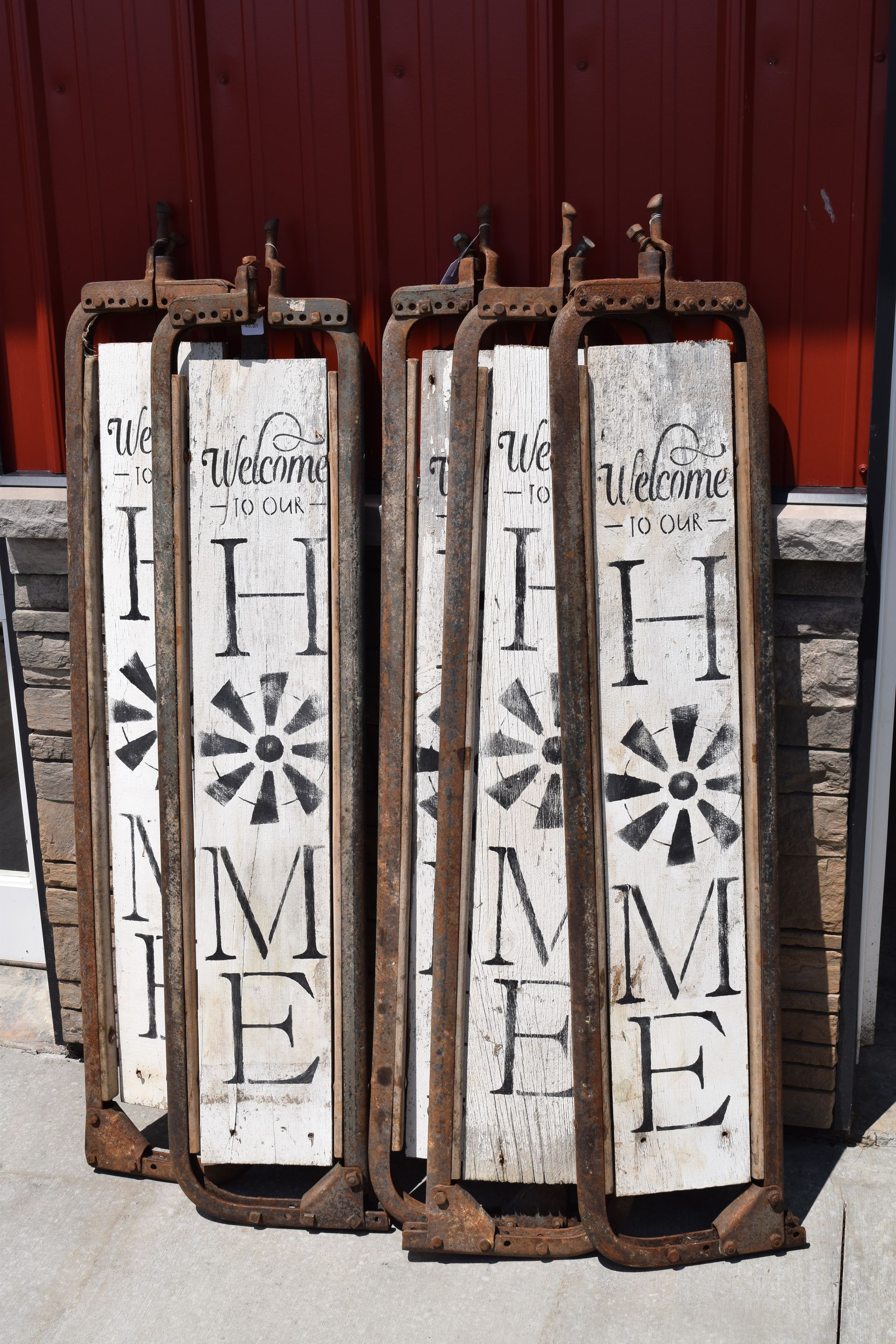 A row of wooden sleds with the word home painted on them