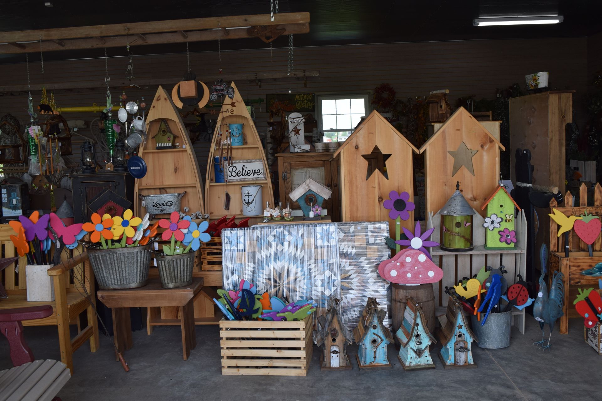 A store filled with lots of wooden decorations and flowers.