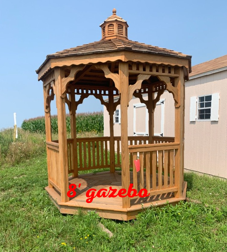A gazebo is sitting in the grass in front of a house