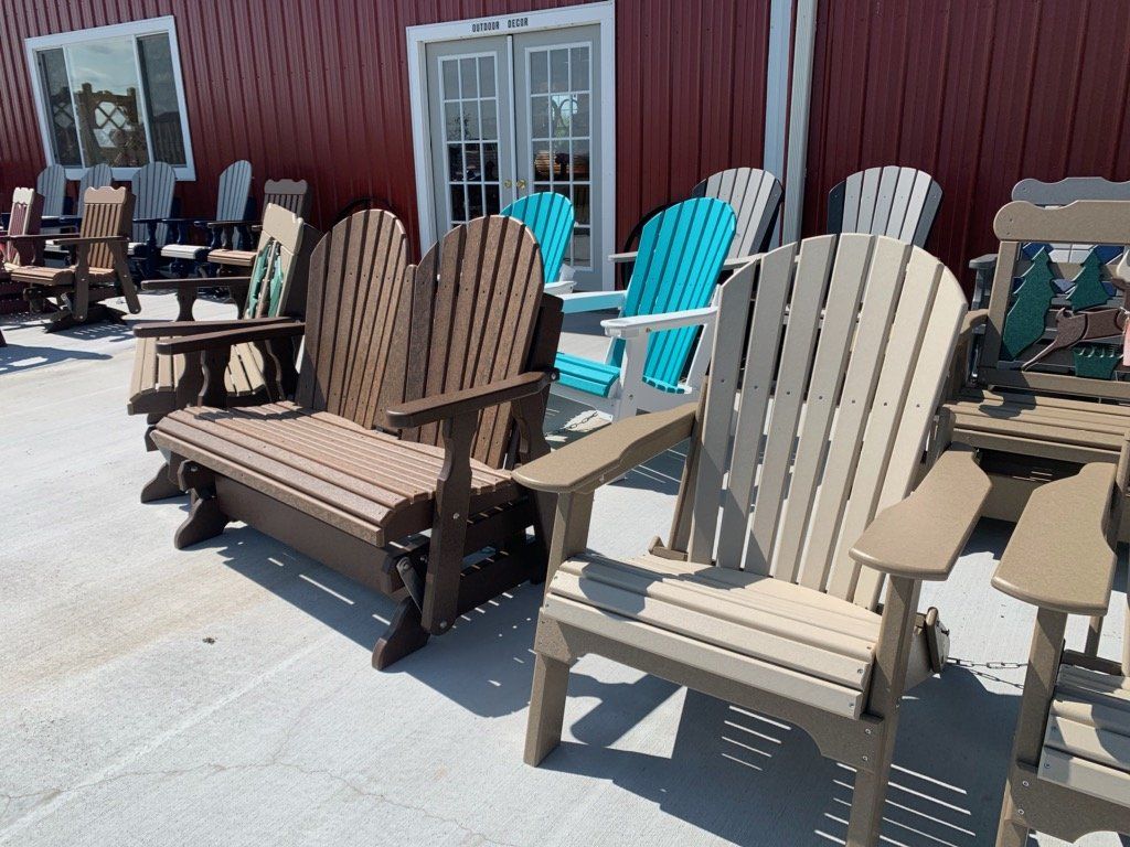 A row of lawn chairs are lined up in front of a red building.