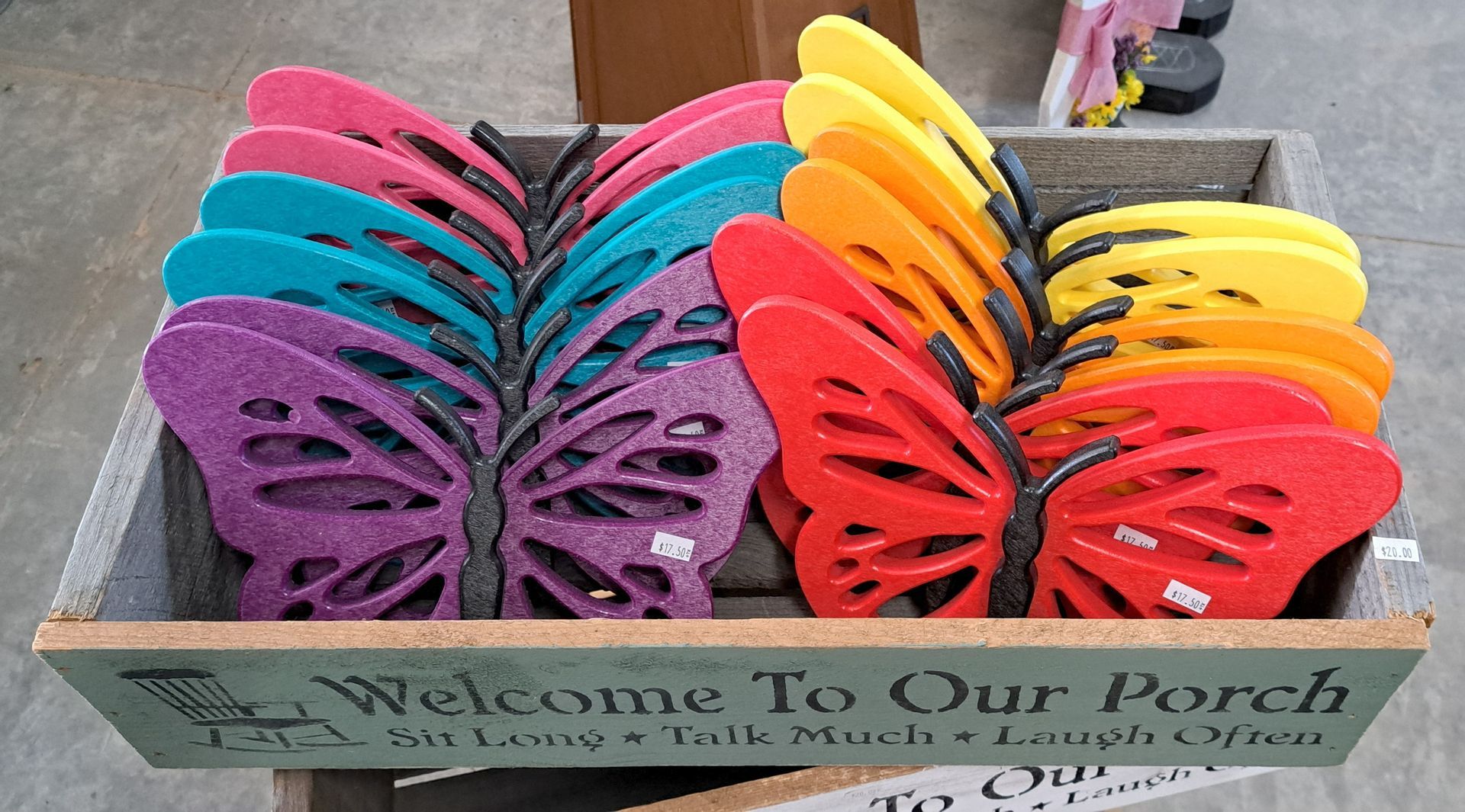 A box of colorful butterflies with a welcome to our porch sign