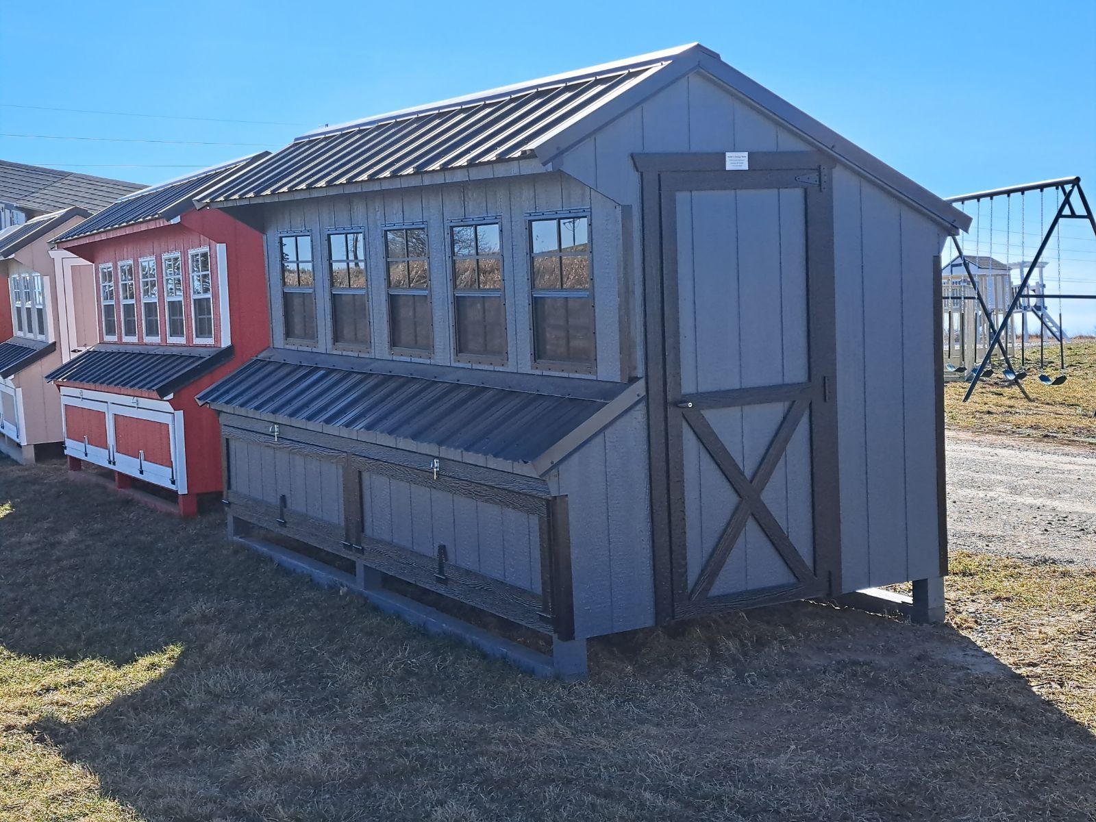 A row of chicken coops are lined up in a field.