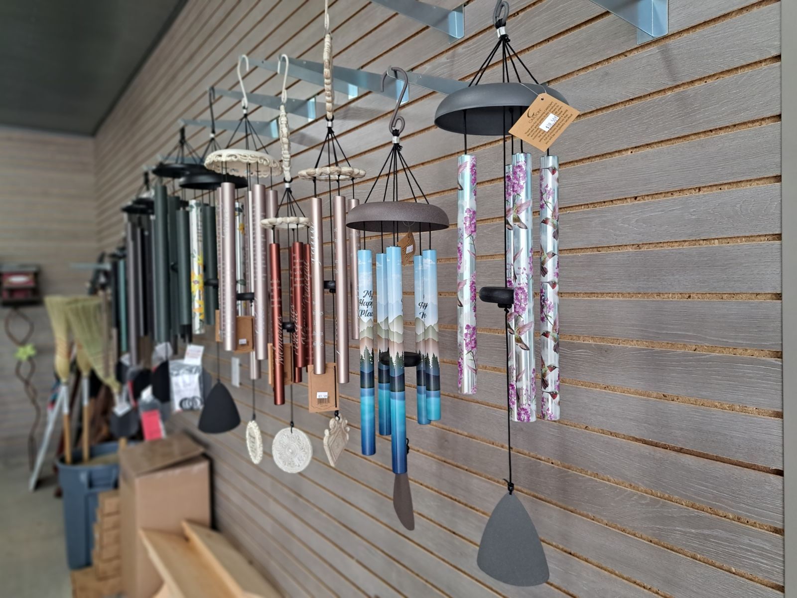 A row of wind chimes hanging on a wall in a store.