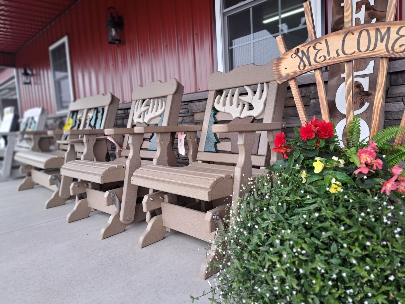 A row of chairs on a porch with a welcome sign in the background.