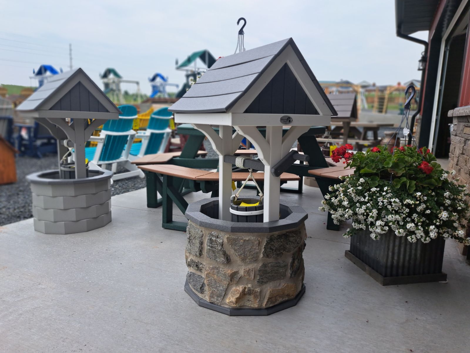 A well with a roof and a planter with flowers in front of it