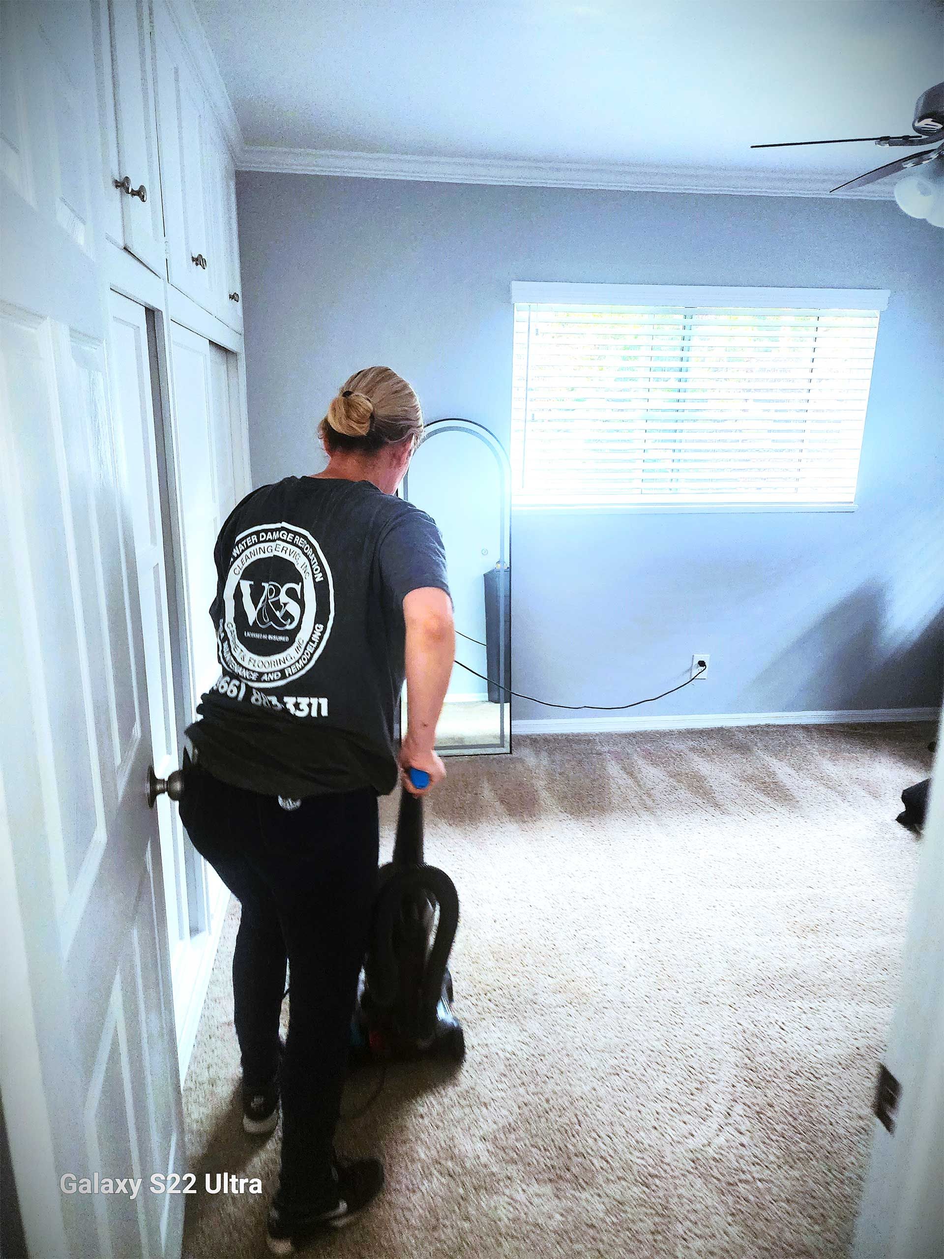 a person cleaning the room with a vacuum