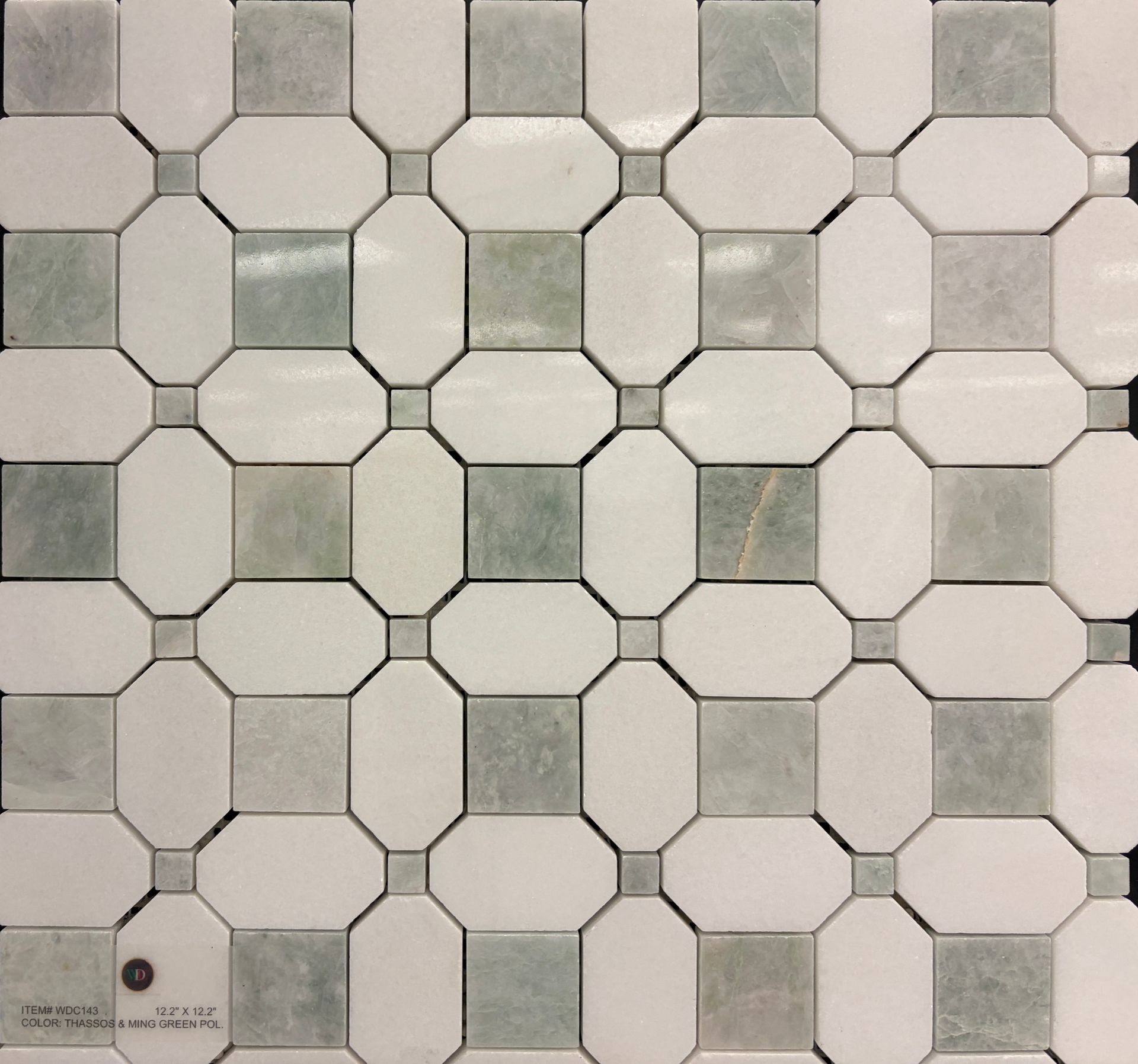 Modern shower with glass doors, white subway tile walls, patterned accent wall, and silver fixtures.