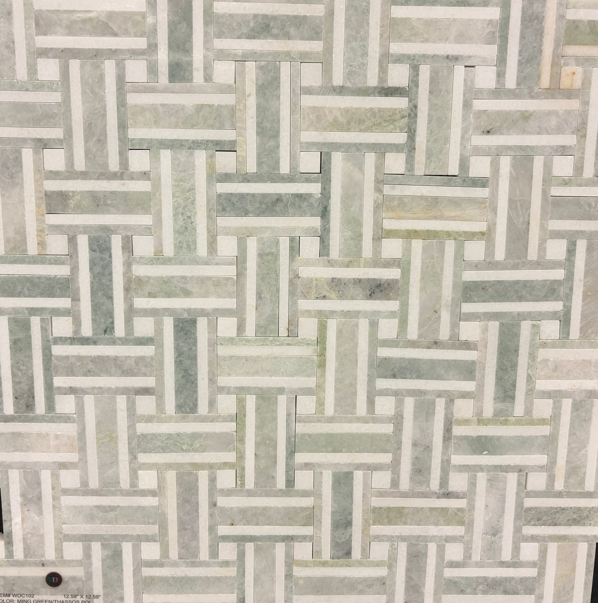 Bathroom with gray vanity, white toilet, and patterned tile floor. A white door is in the background.