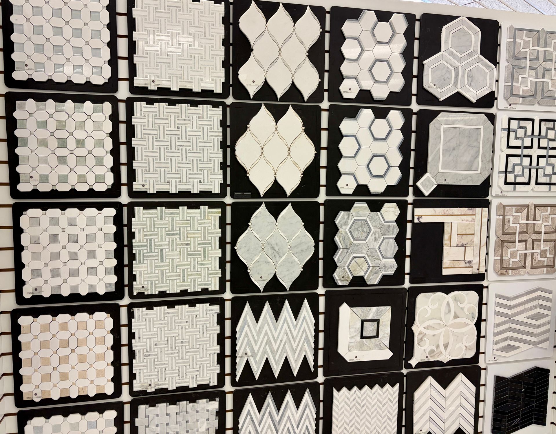 Bathroom with white marble shower, clear glass doors, and patterned floor tile.