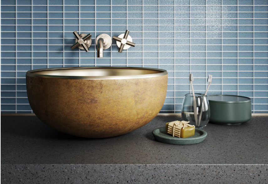 Bathroom with blue tile wall, copper basin sink, and chrome faucet.