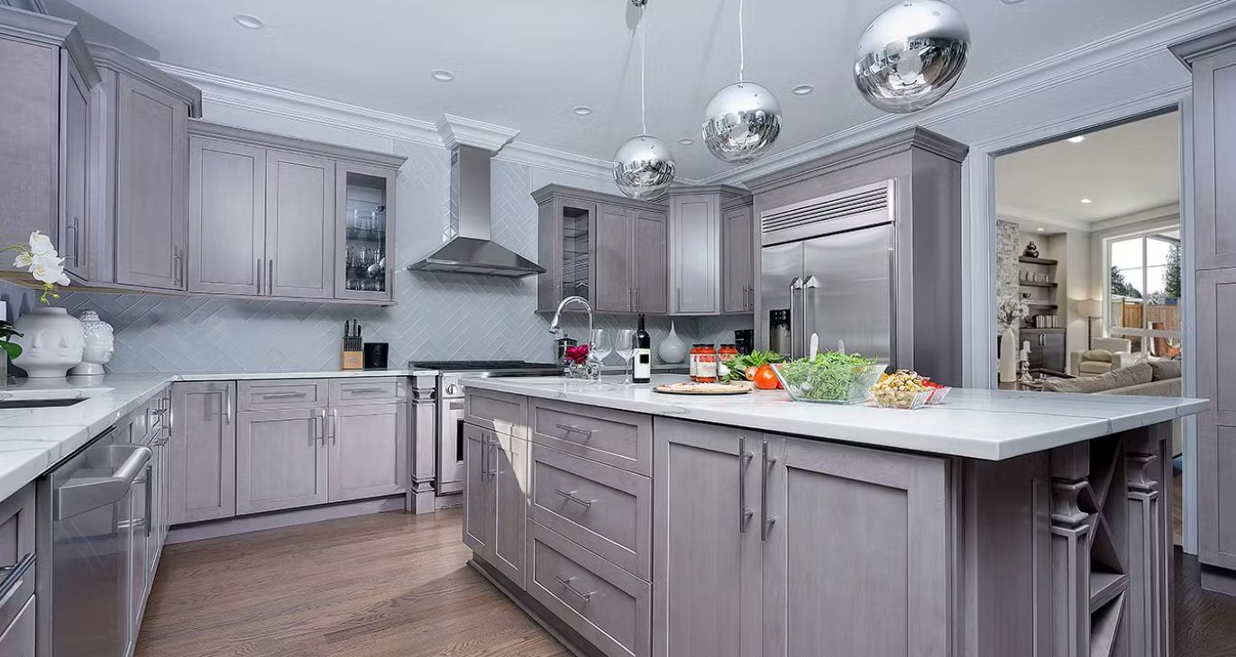 Gray kitchen with stainless steel appliances, marble countertops, and a central island.
