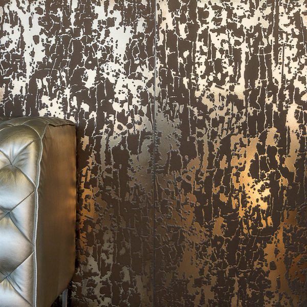 Brown and gold textured wall with a gold tufted sofa partially visible.