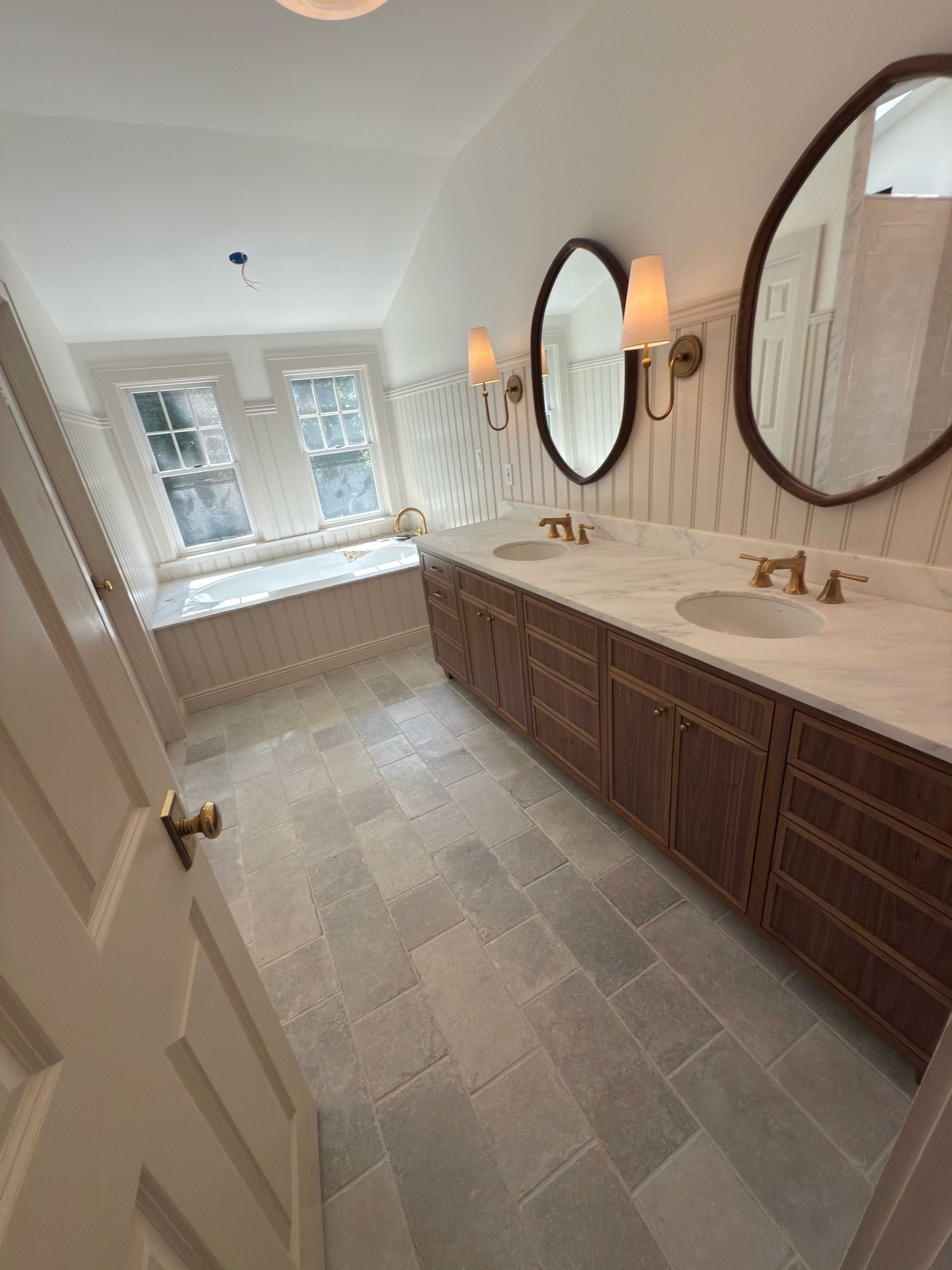 Elegant bathroom with a double vanity, marble countertops, and patterned tile.