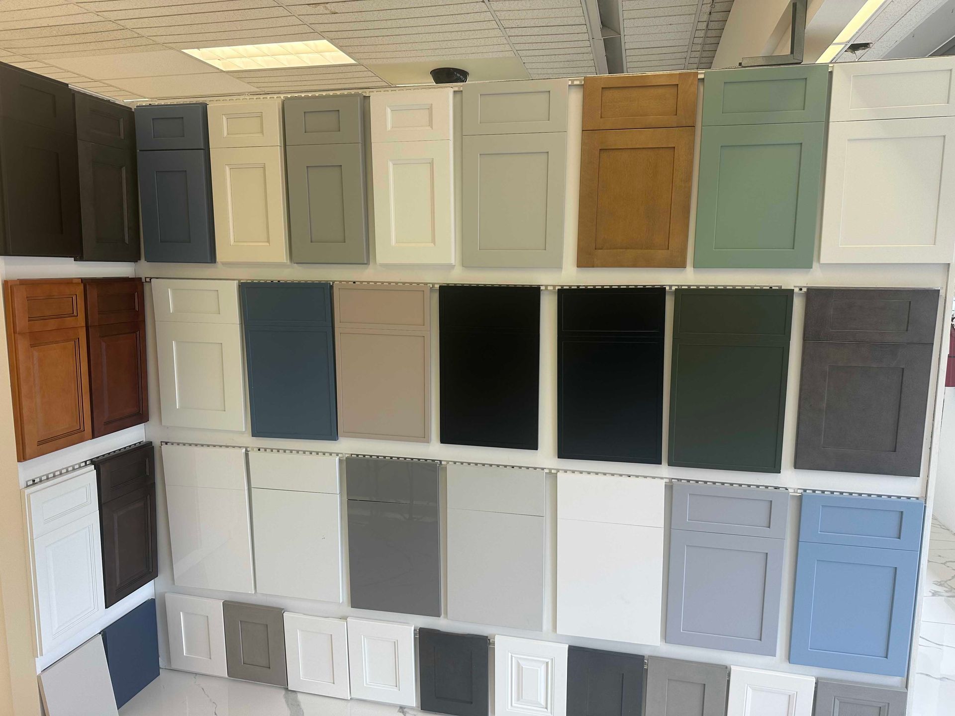 Cabinet door samples in various colors displayed on a wall.