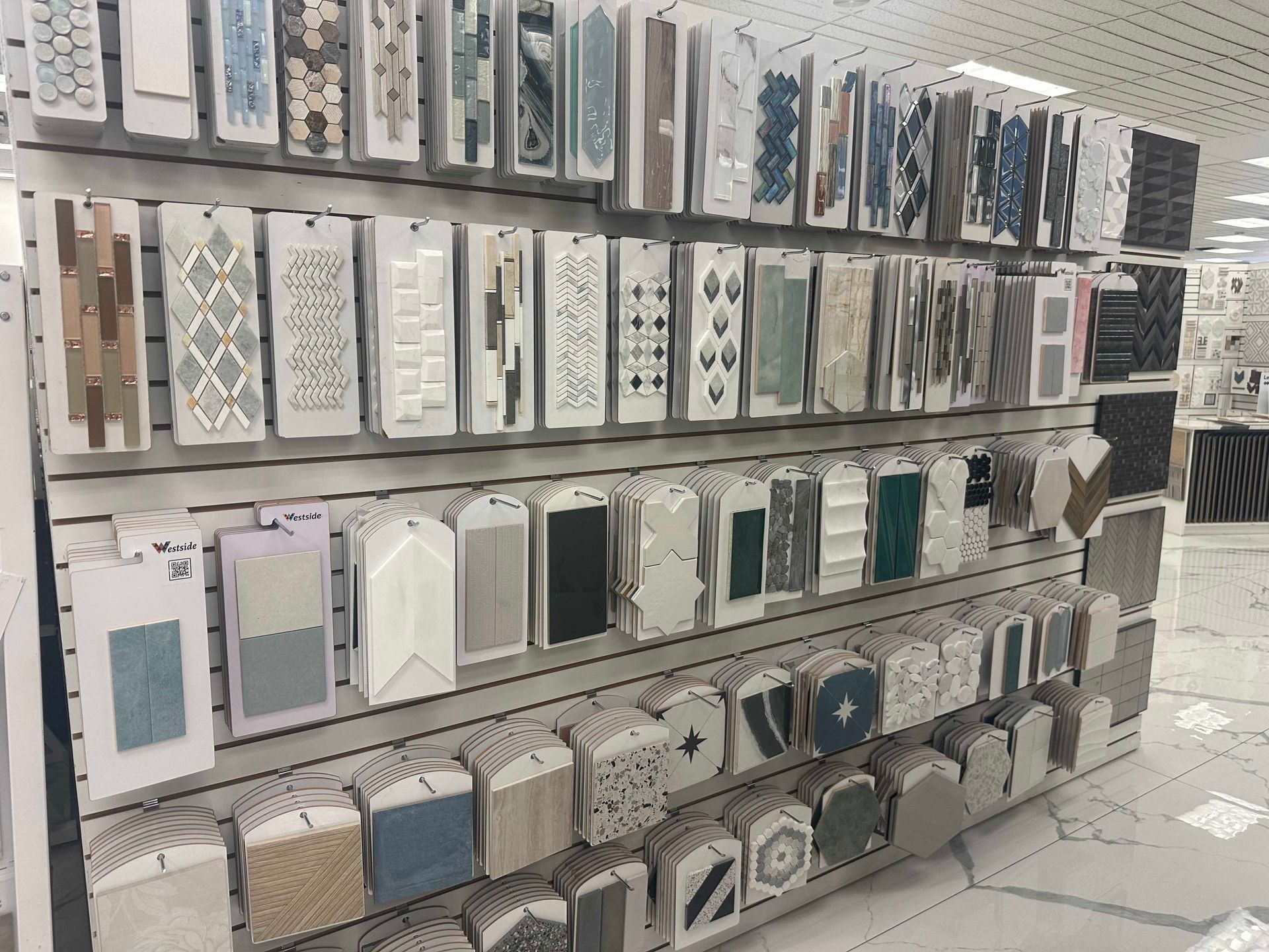 Tile samples displayed on store shelving. Various colors and patterns are shown.