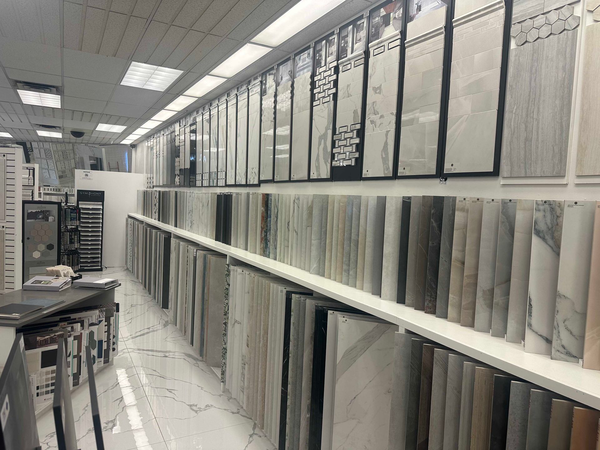 Tile showroom with rows of tile samples on display, showcasing various colors and textures.