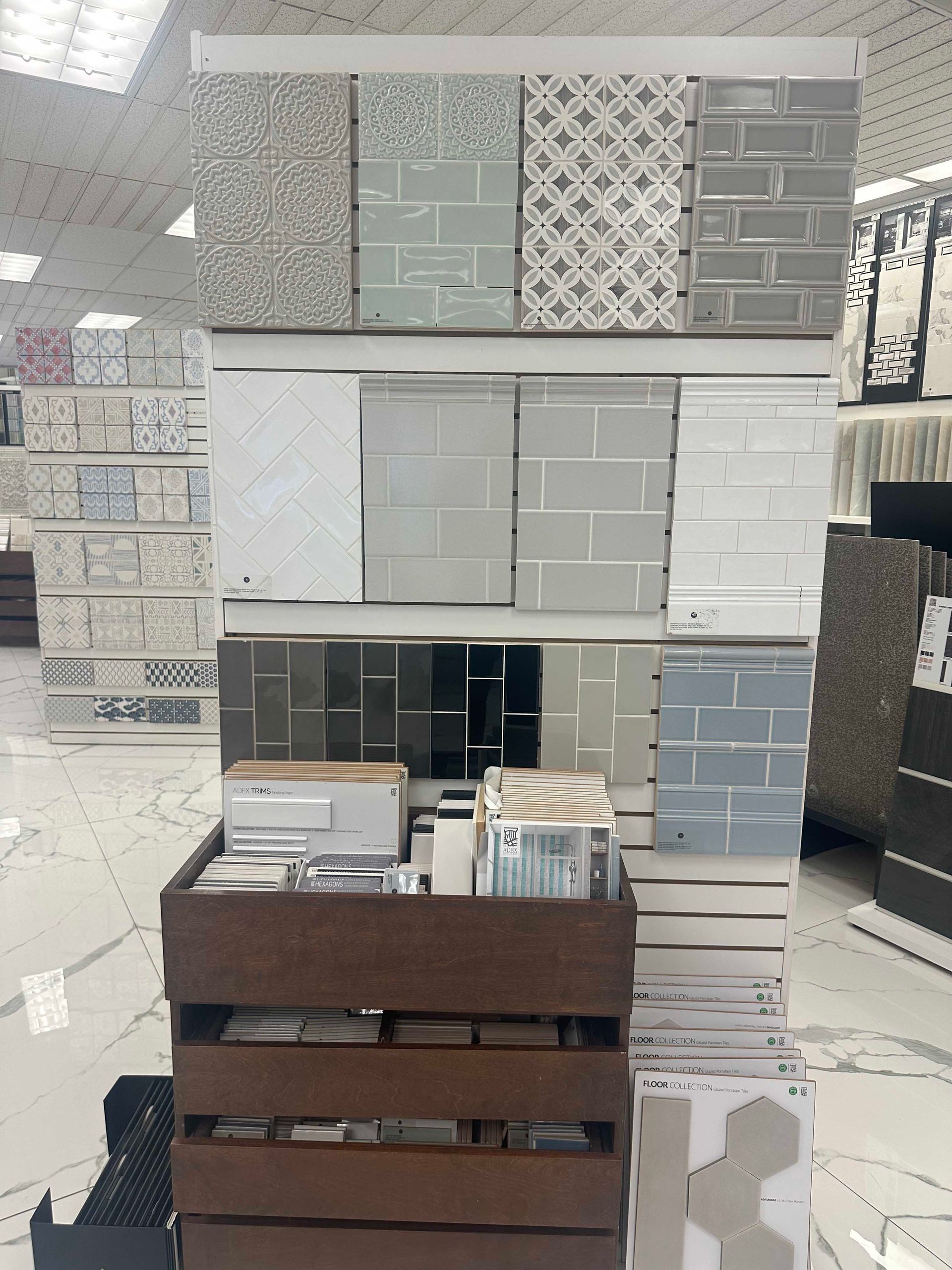 Tile display rack in a store, showcasing various tile samples in different colors and patterns.
