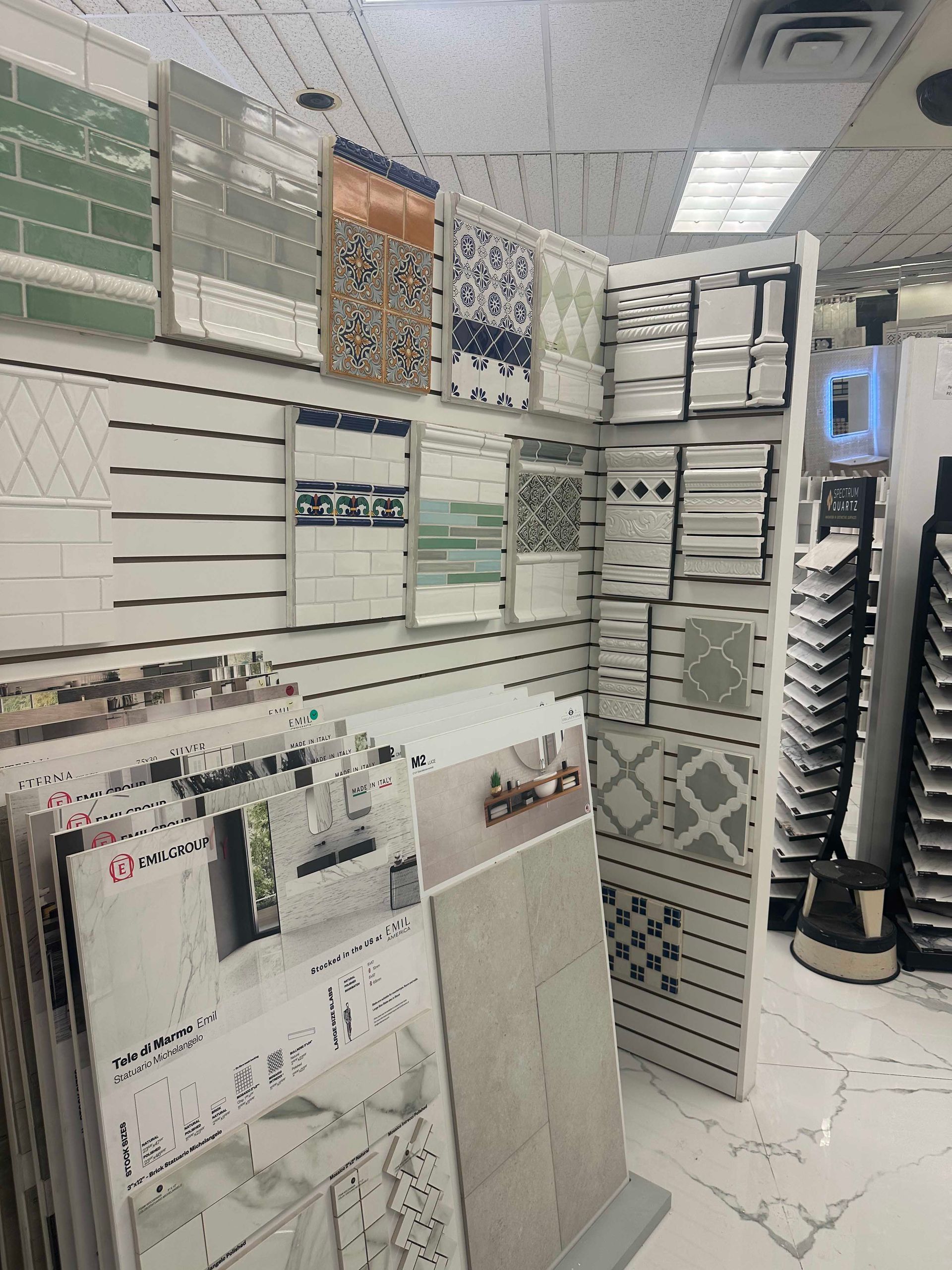 Tile samples displayed in a showroom, various colors and patterns.