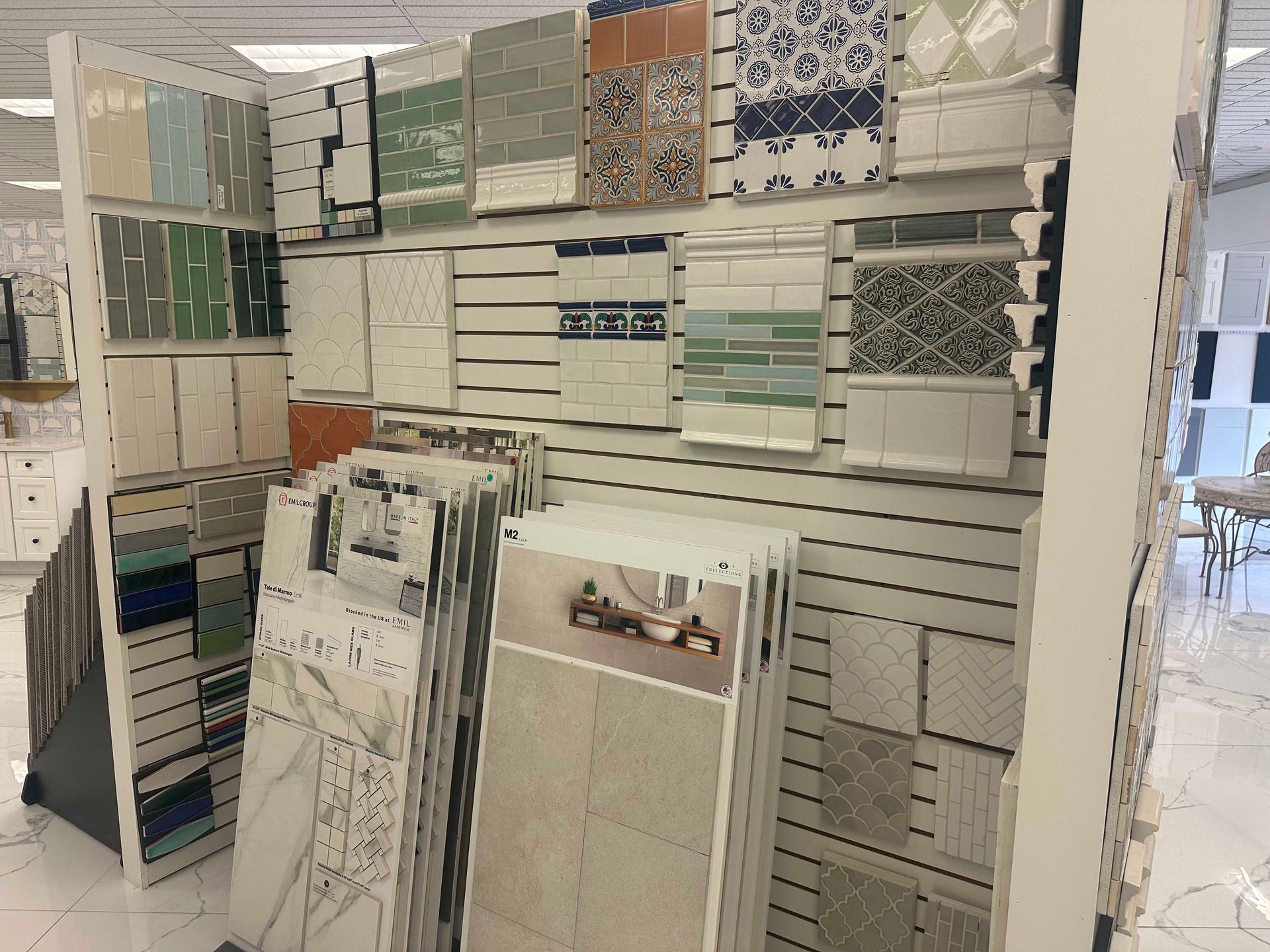 Tile display with various patterns and colors in a showroom.