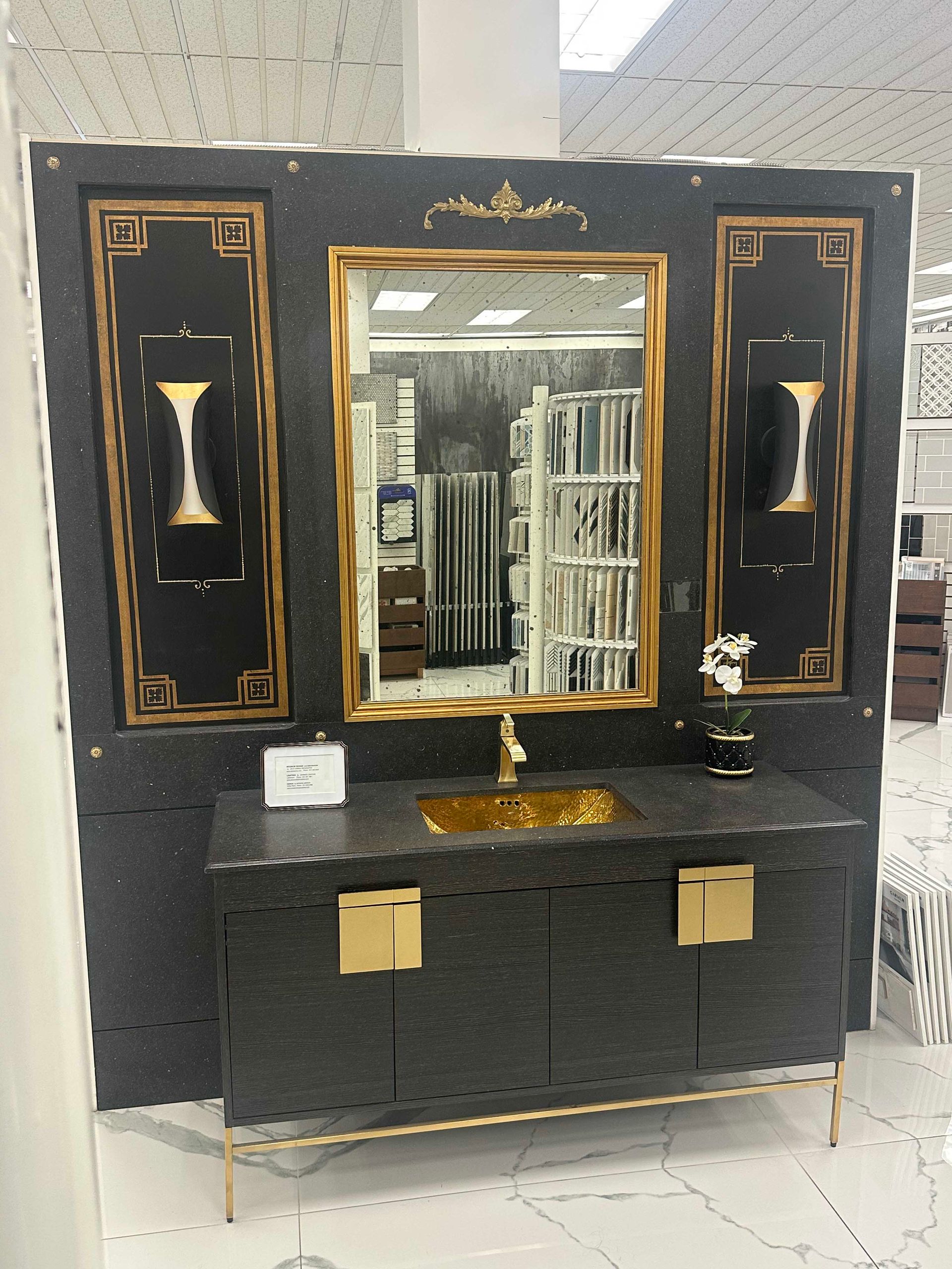 Black and gold bathroom vanity set. Features a sink, mirror, and cabinet with gold accents.