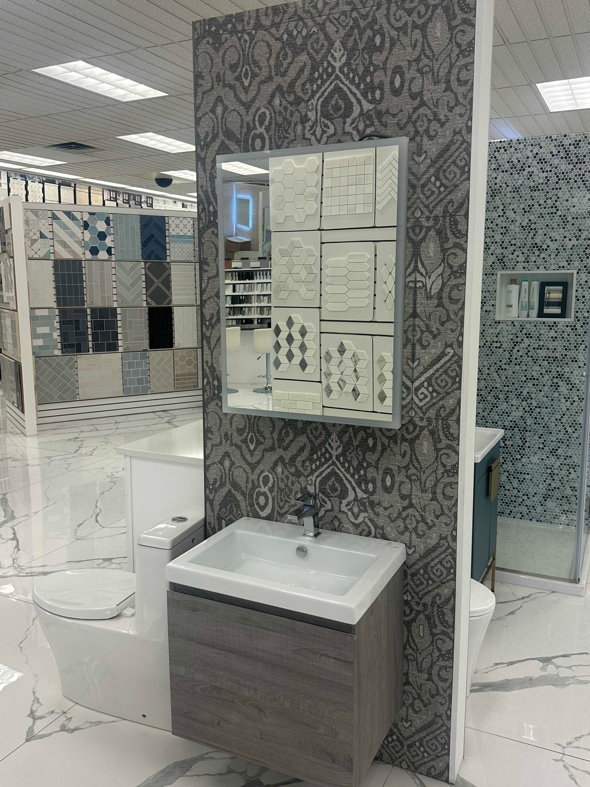 Bathroom display featuring a sink, vanity, mirror, and decorative patterned wall tile.