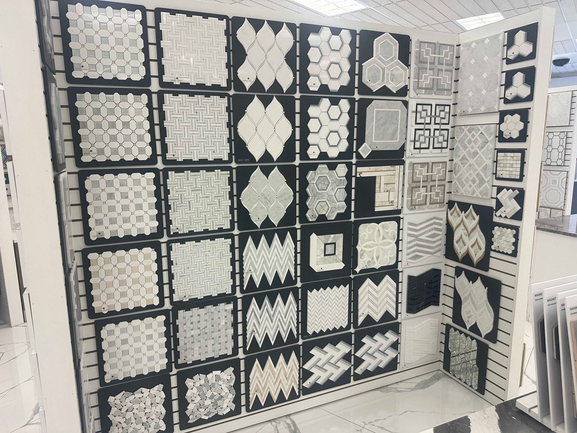Tile display featuring various patterns and textures in a showroom setting.