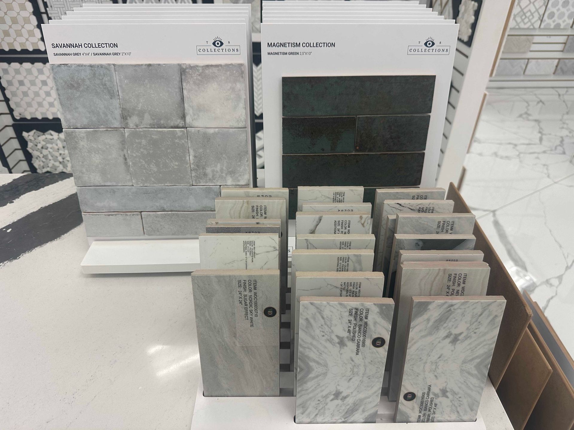 Tile samples on display, showcasing various textures and colors, in a showroom setting.