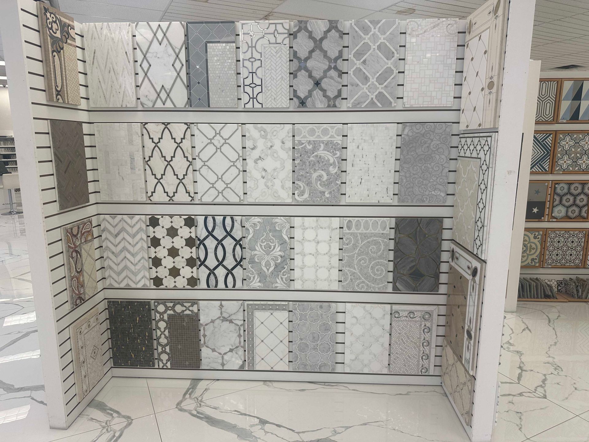 Tiles display in a store, showcasing various patterns and neutral colors.
