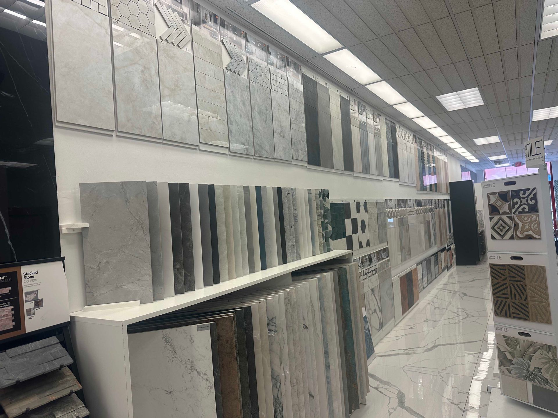Tile showroom with various tile samples displayed on walls and shelves.