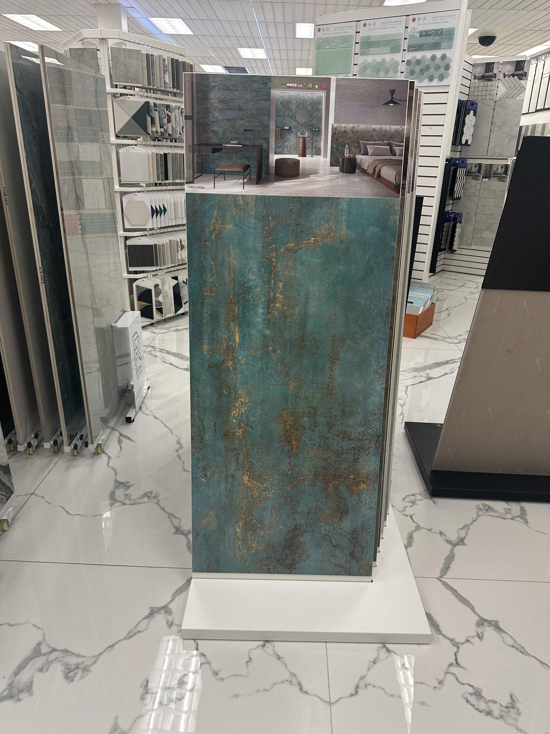 Display of turquoise and gold textured tile in a showroom, displayed on a white stand with marble flooring.