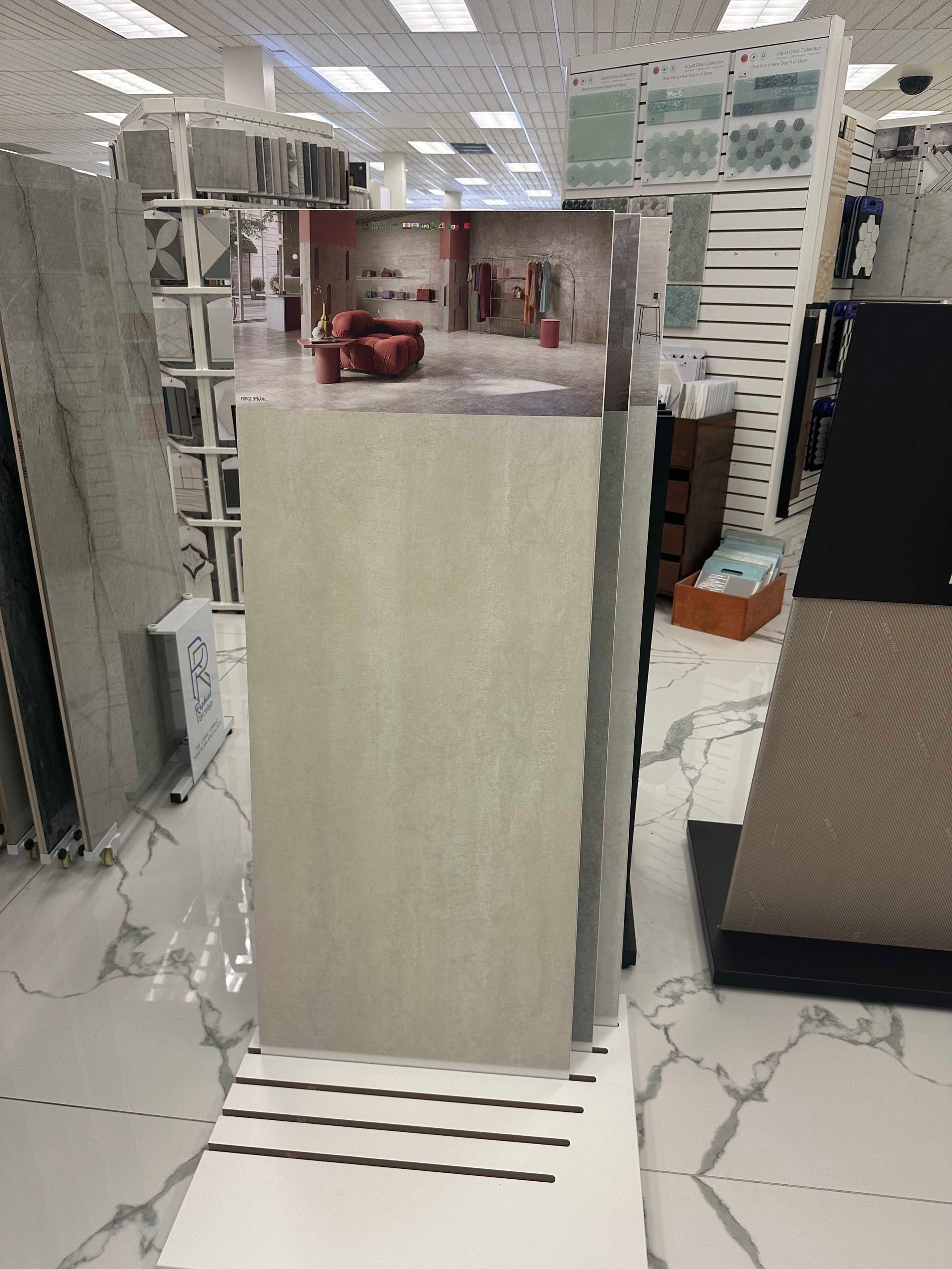 Display of rectangular beige ceramic tiles in a store. White flooring and bright overhead lighting.