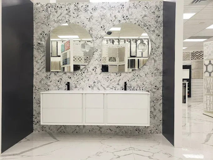 Bathroom display with white floating vanity, two round mirrors, and marble-look tile.