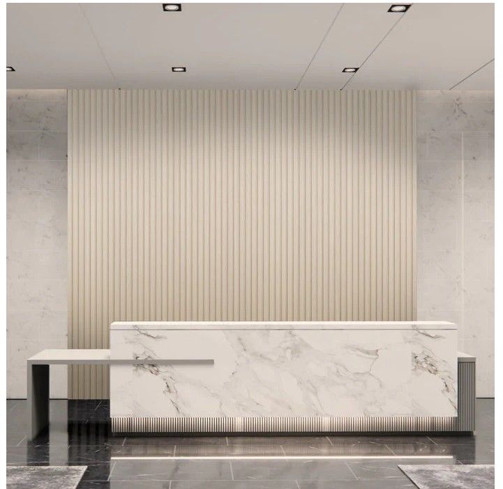 Reception desk in an office with marble design and vertical wood paneling background.