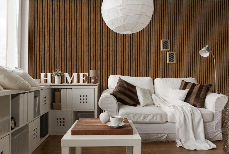 Living room with a white sofa, wooden accent wall, and decorative shelves.