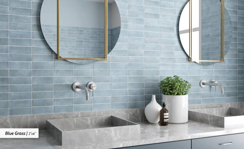 Bathroom with blue tile wall, two round mirrors, and gray countertops.
