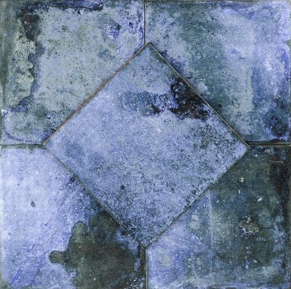 Blue and green square tiles with a central diamond-shaped tile; weathered, mottled appearance.