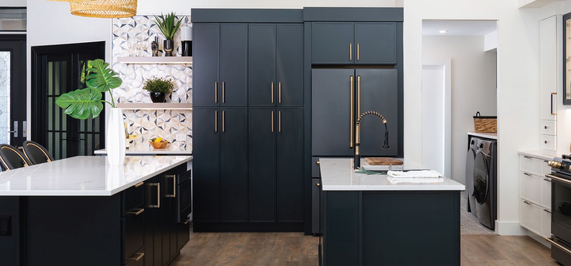 Modern kitchen with dark blue cabinets, white countertops, and wood floors.