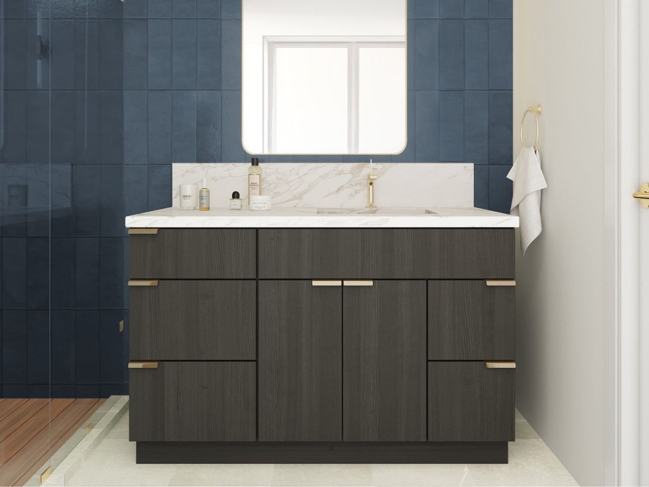 Bathroom vanity with dark wood cabinets, marble countertop, gold hardware, and blue tile backsplash.
