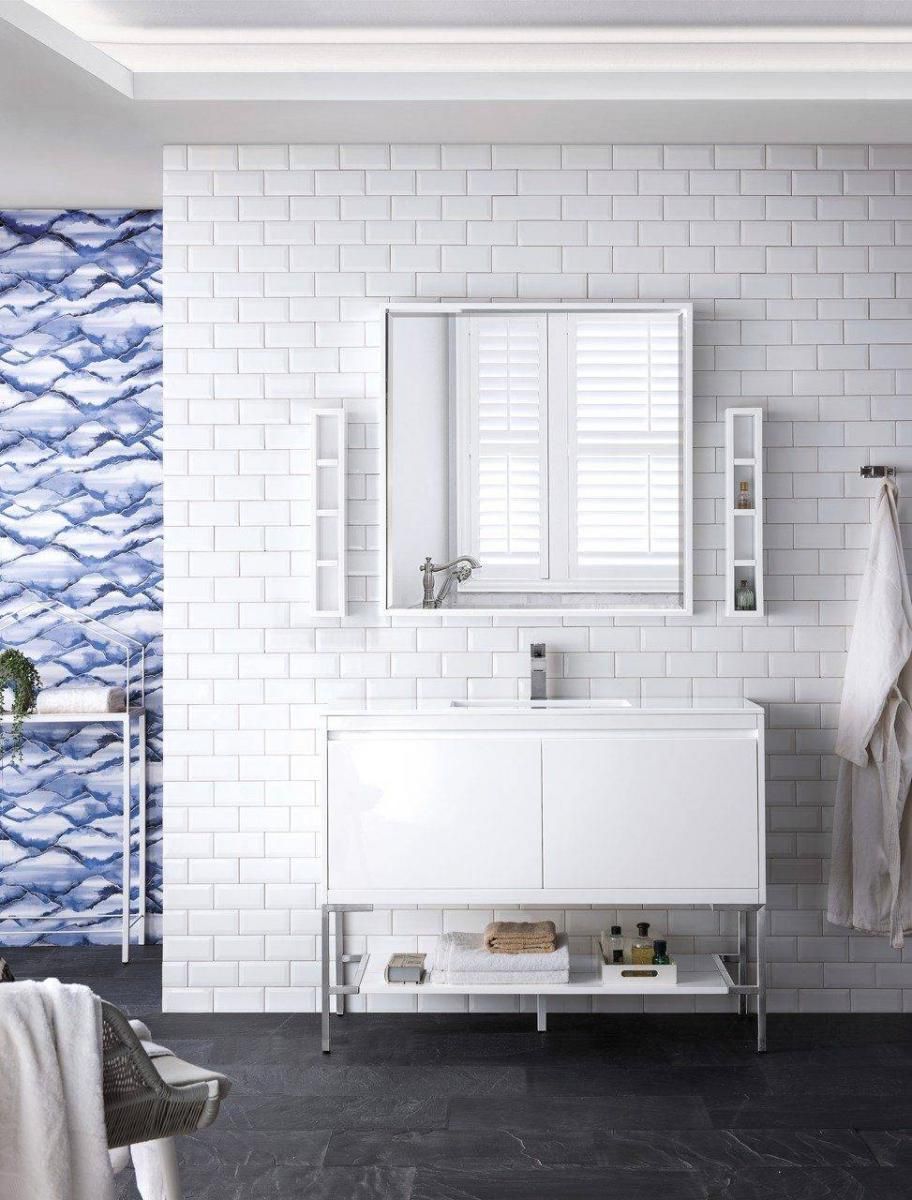 Modern white bathroom with vanity, mirror, and blue patterned wall accent.
