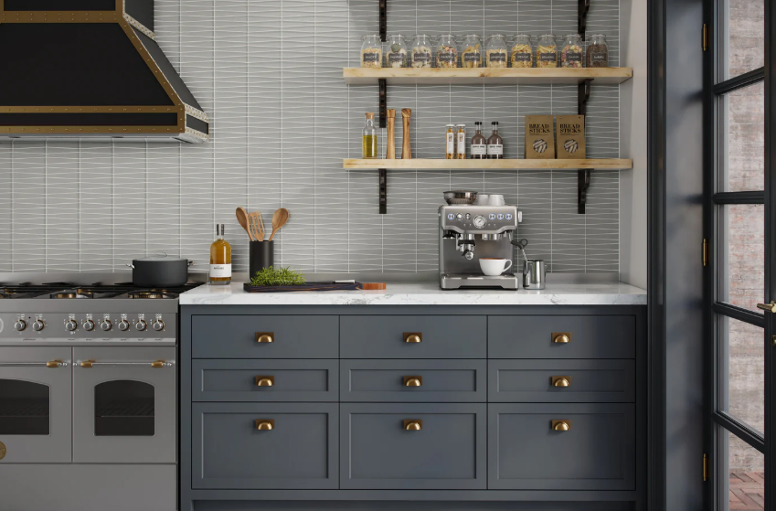 Stylish kitchen with grey cabinets, marble countertop, and stove, with espresso machine on the counter.