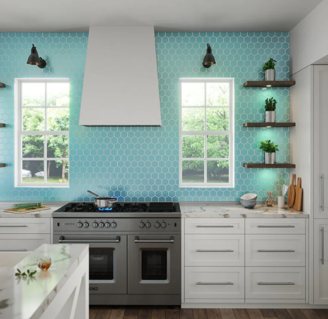 Kitchen with blue tile backsplash, white cabinets, stainless steel stove, and windows.