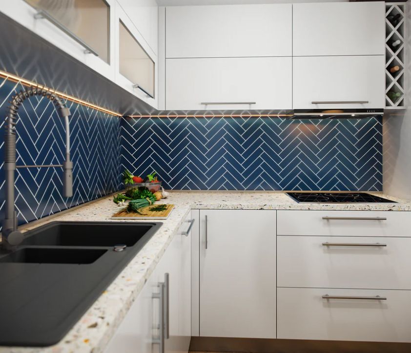 Modern white kitchen with blue herringbone tile backsplash and dark sink.