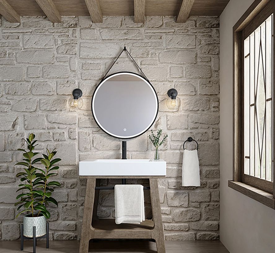 Bathroom with a white brick wall, wooden sink stand, round mirror, and a window.