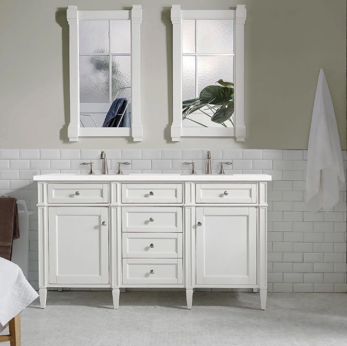 White double vanity with two mirrors in a bathroom with white subway tile.
