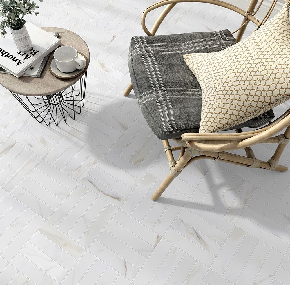 White marble floor with a rattan chair, throw blanket, pillow, and side table.