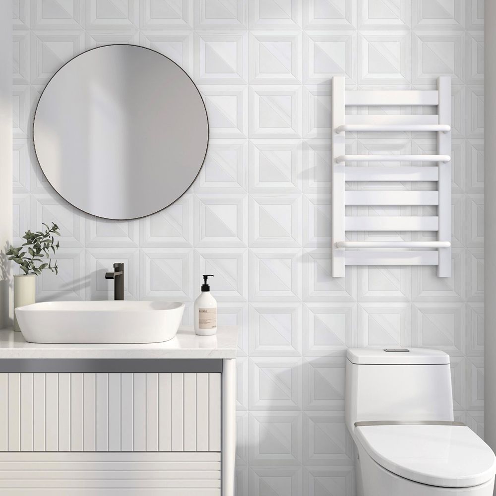 White bathroom with a sink, mirror, toilet, and towel rack against a textured wall.