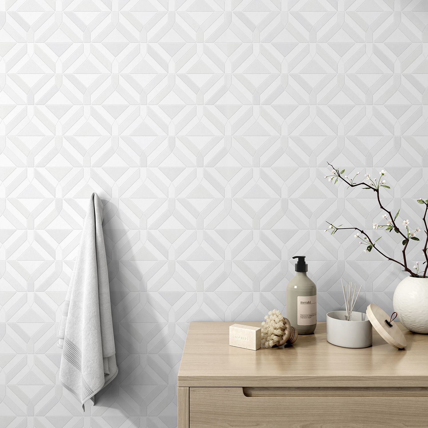 White patterned tiled bathroom wall with a wooden vanity, towel, and toiletries.