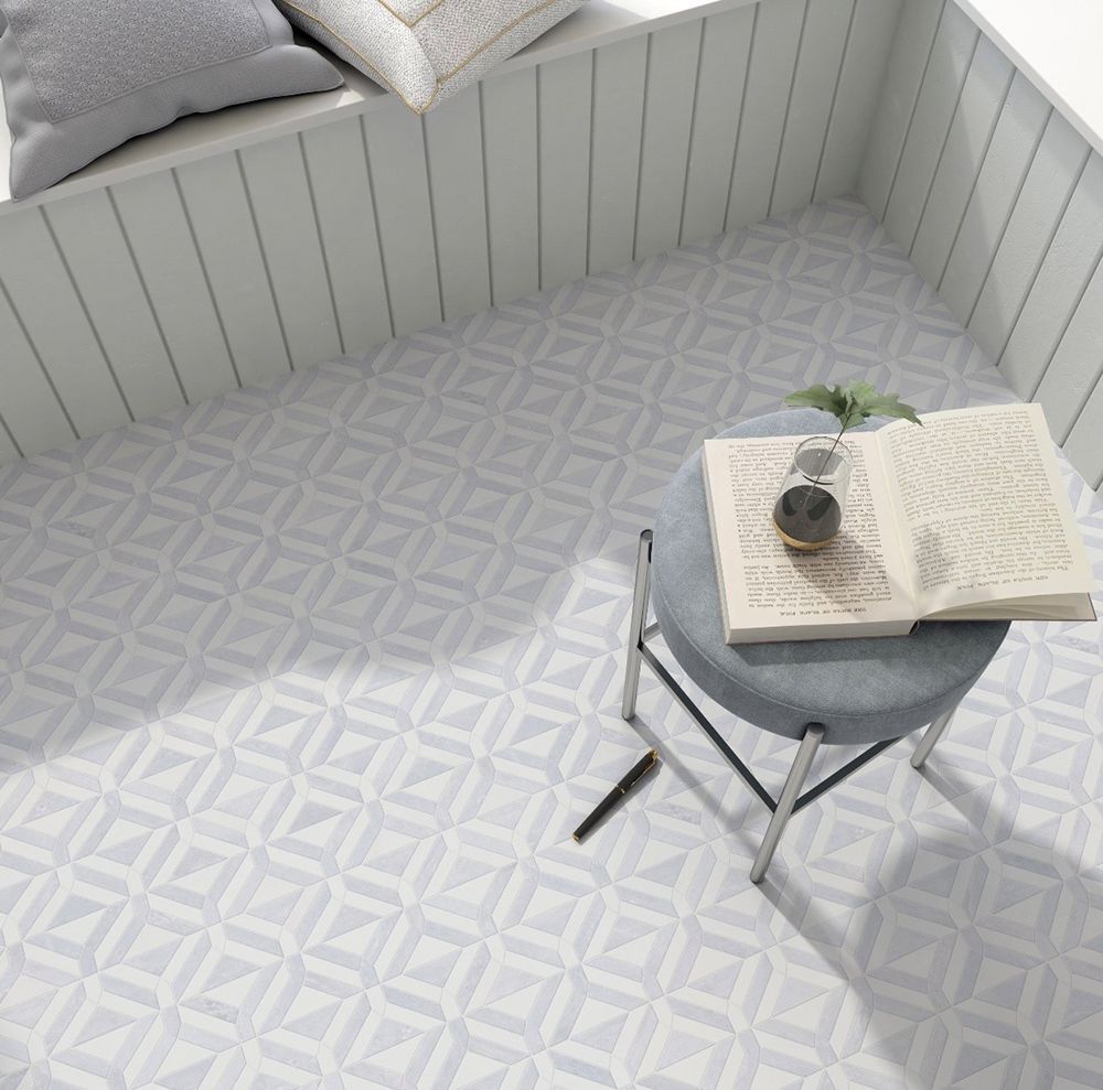 Room with geometric patterned floor, stool with book and plant, window with cushions.