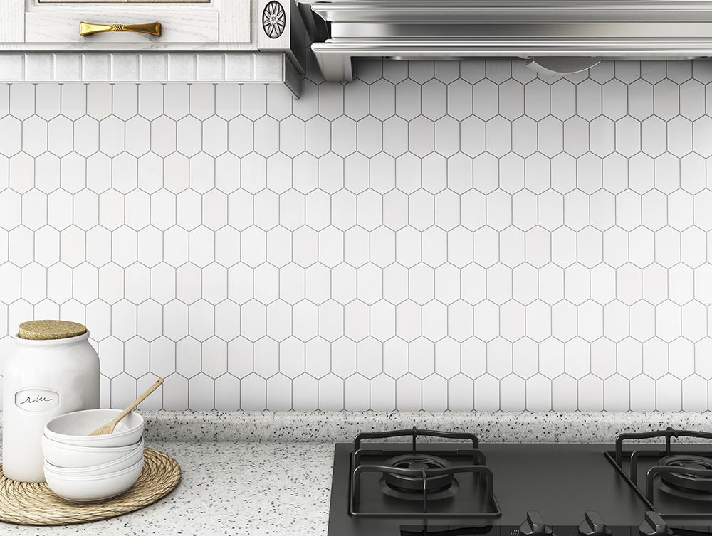 White tiled kitchen backsplash with stove, countertop, and decor.