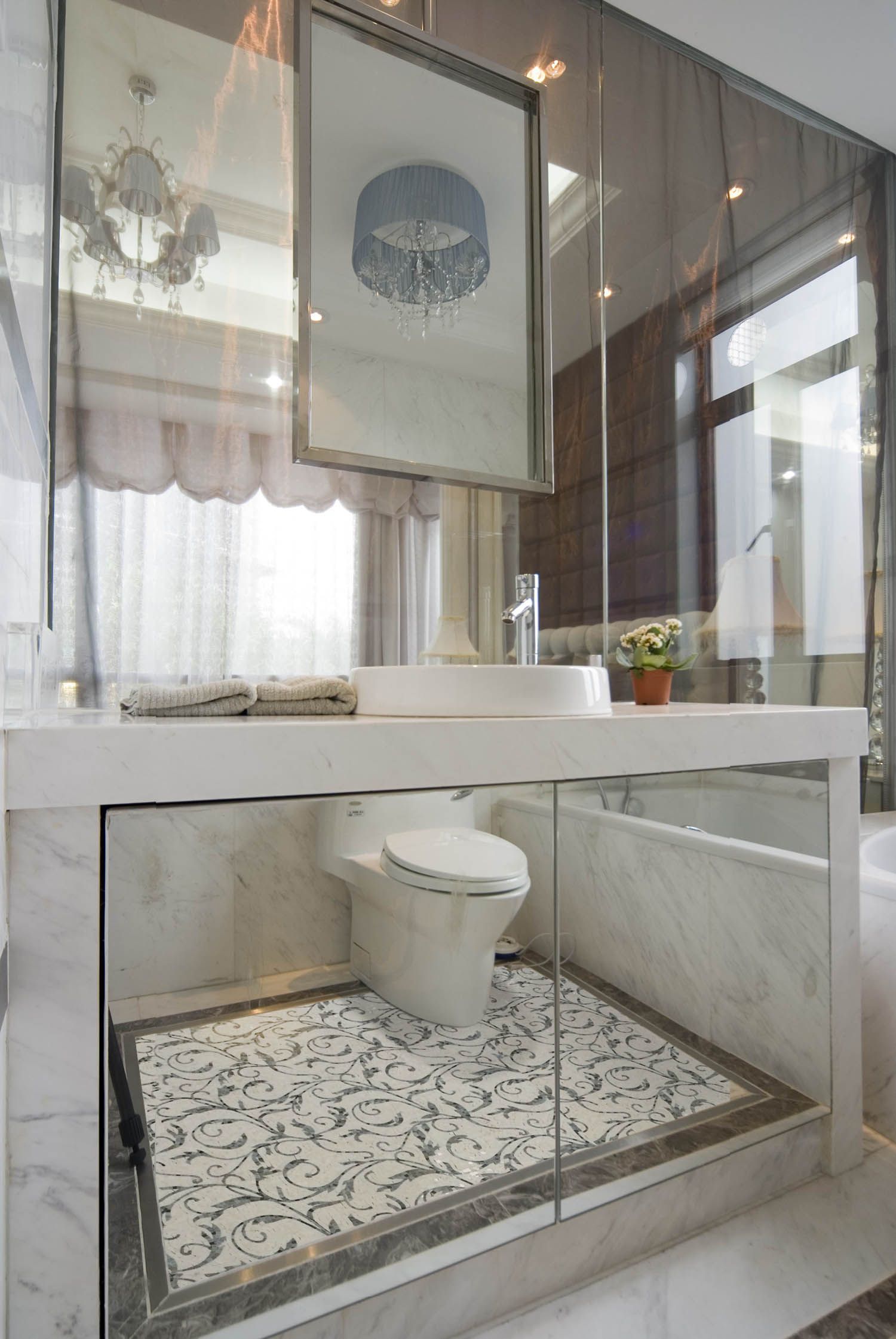 Luxurious bathroom with mirrored walls, a marble vanity, and a toilet.